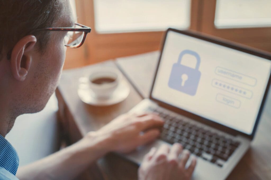 Homem de óculos olhando computador com cadeado