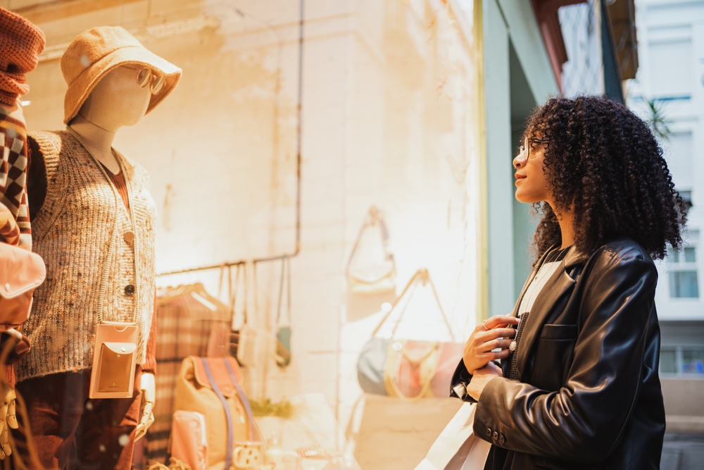 mulher olhando roupas na vitrine de loja