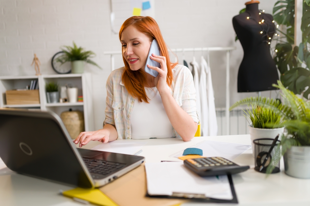 mulher ao telefone olhando para o notebook