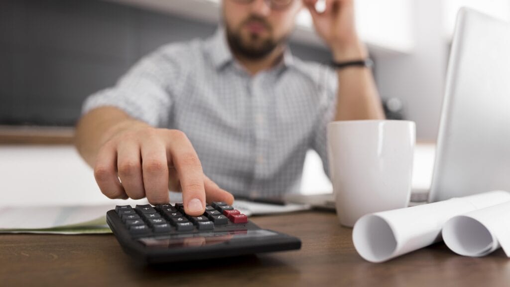 homem no escritório calculando na calculadora