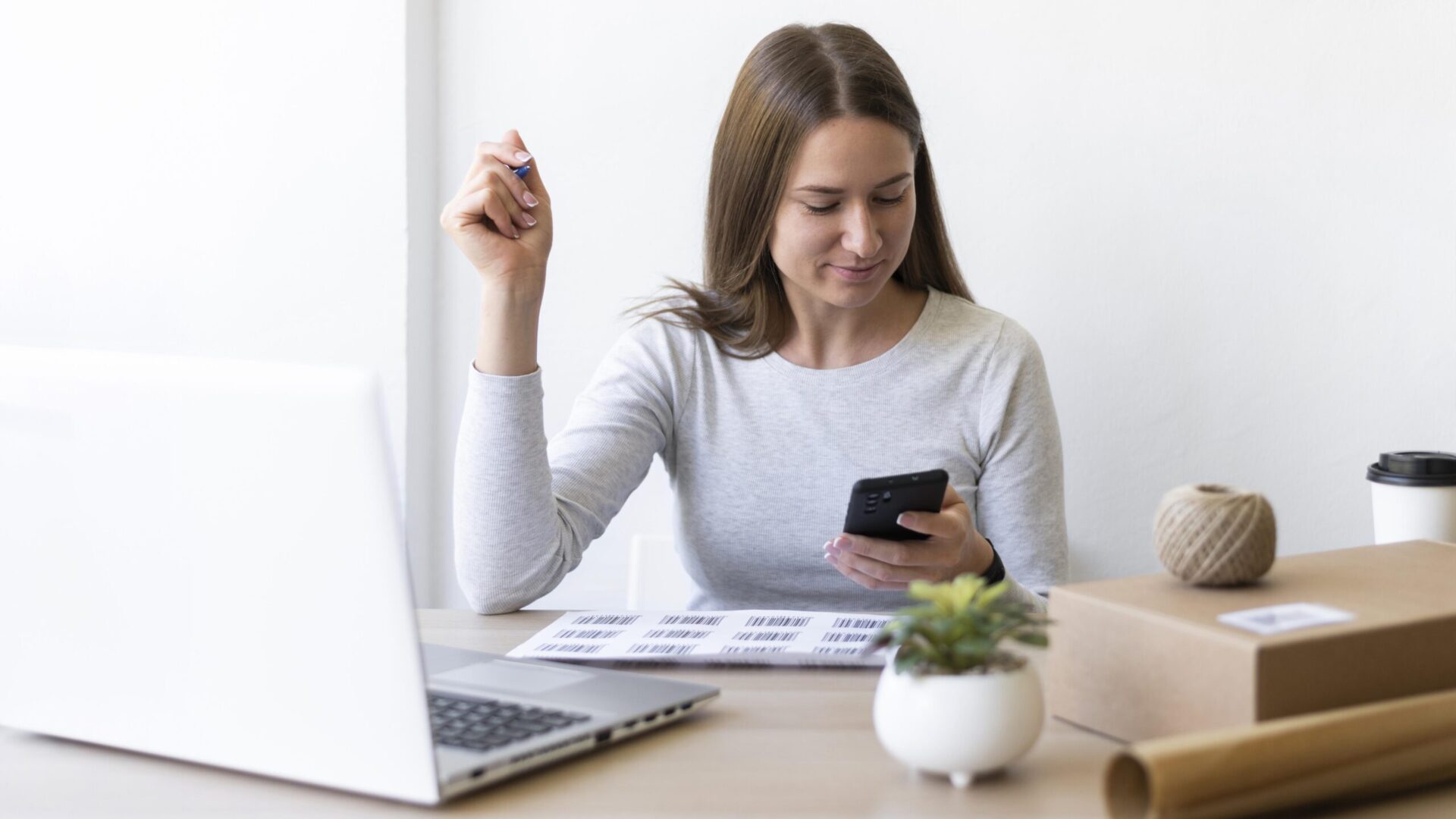 mulher em um escritório olhando para o celular sorrindo