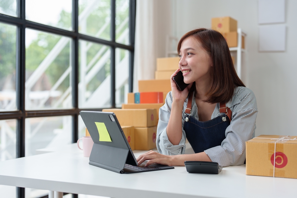 empreendedora em seu pequeno negócio falando ao telefone