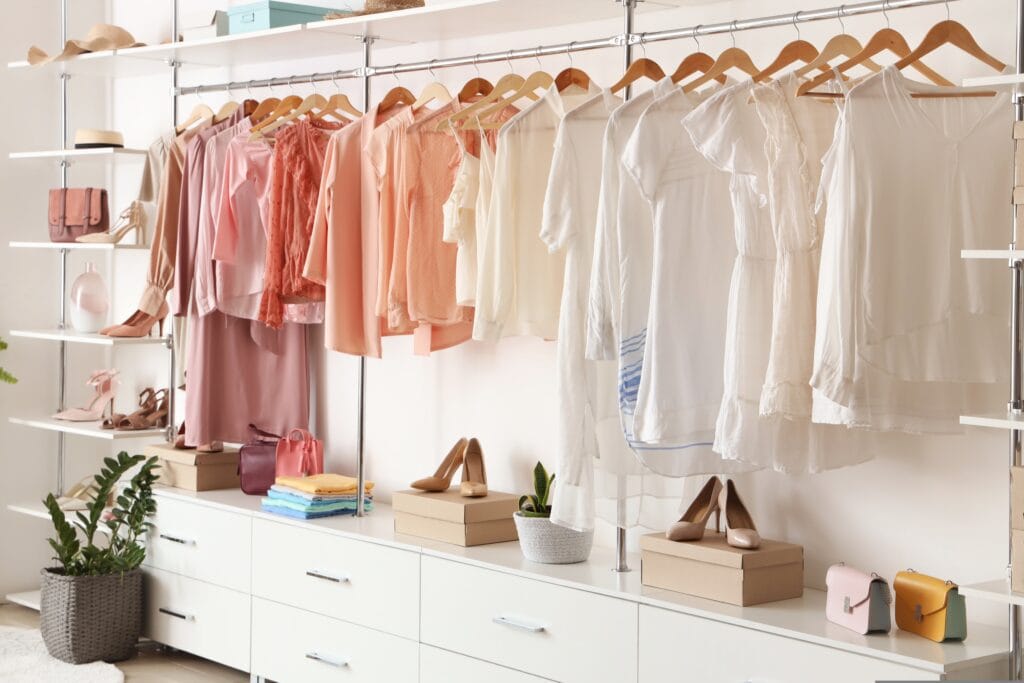 araras de uma loja de roupas com algumas roupas e acessórios femininos pendurados