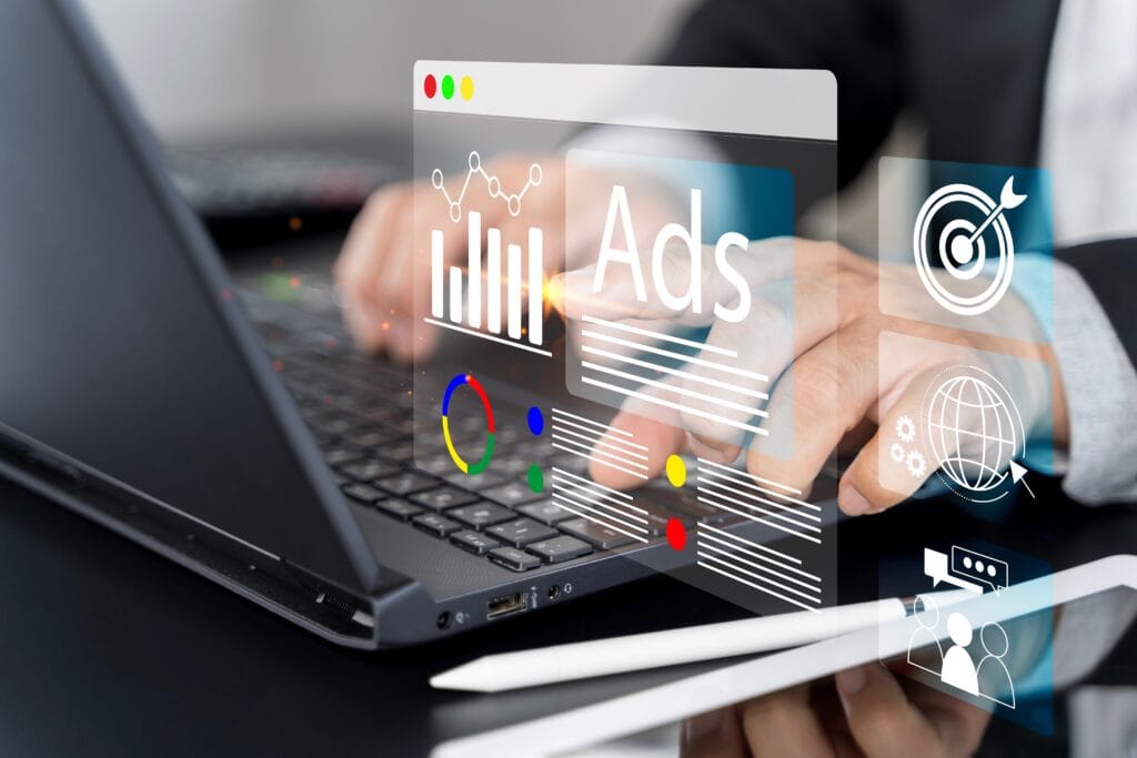 pessoa digitando no notebook com gráficos de ads em 3D sobre o teclado