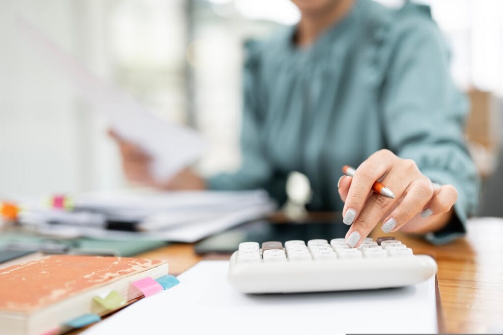 mulher de negócios calculando e mexendo em papeis