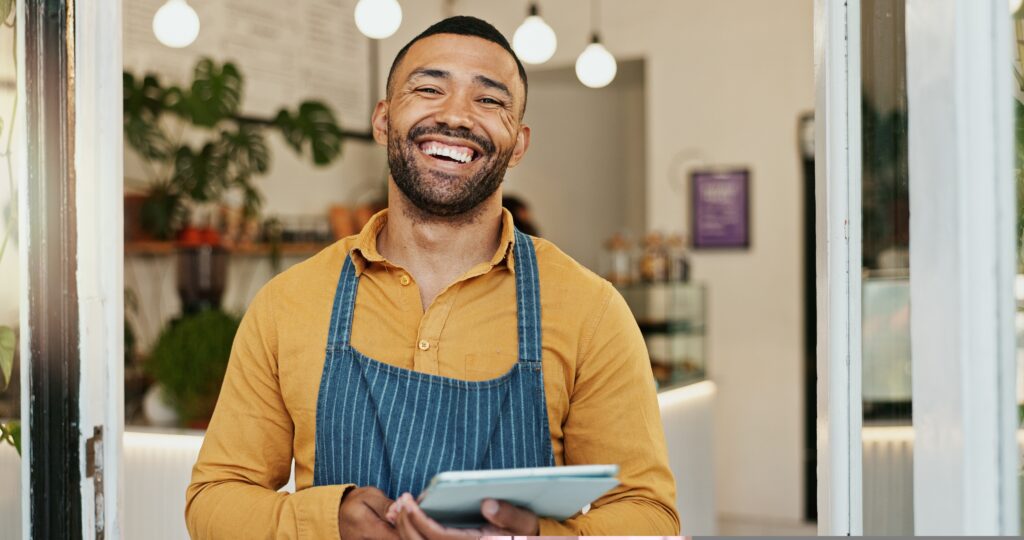 dono de loja com tablet na mão sorrindo