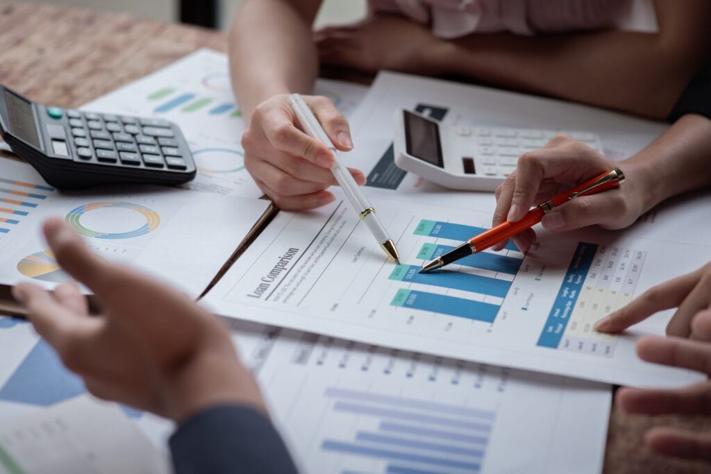 pessoas do financeiro analisando gráficos sobre a mesa