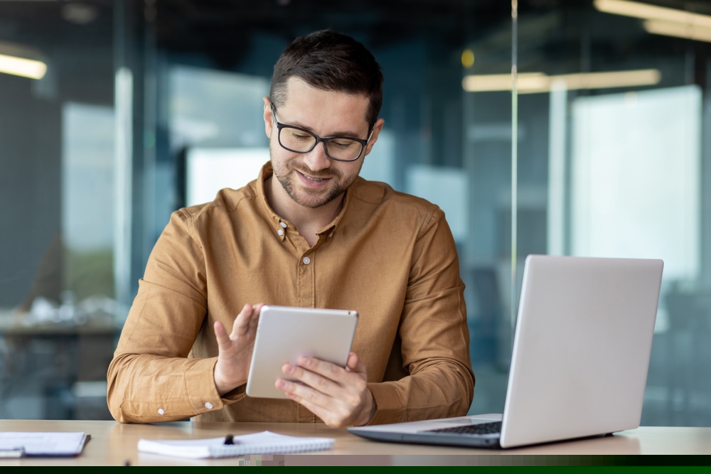 empreendedor sentado e sorrindo enquanto analisa papeis